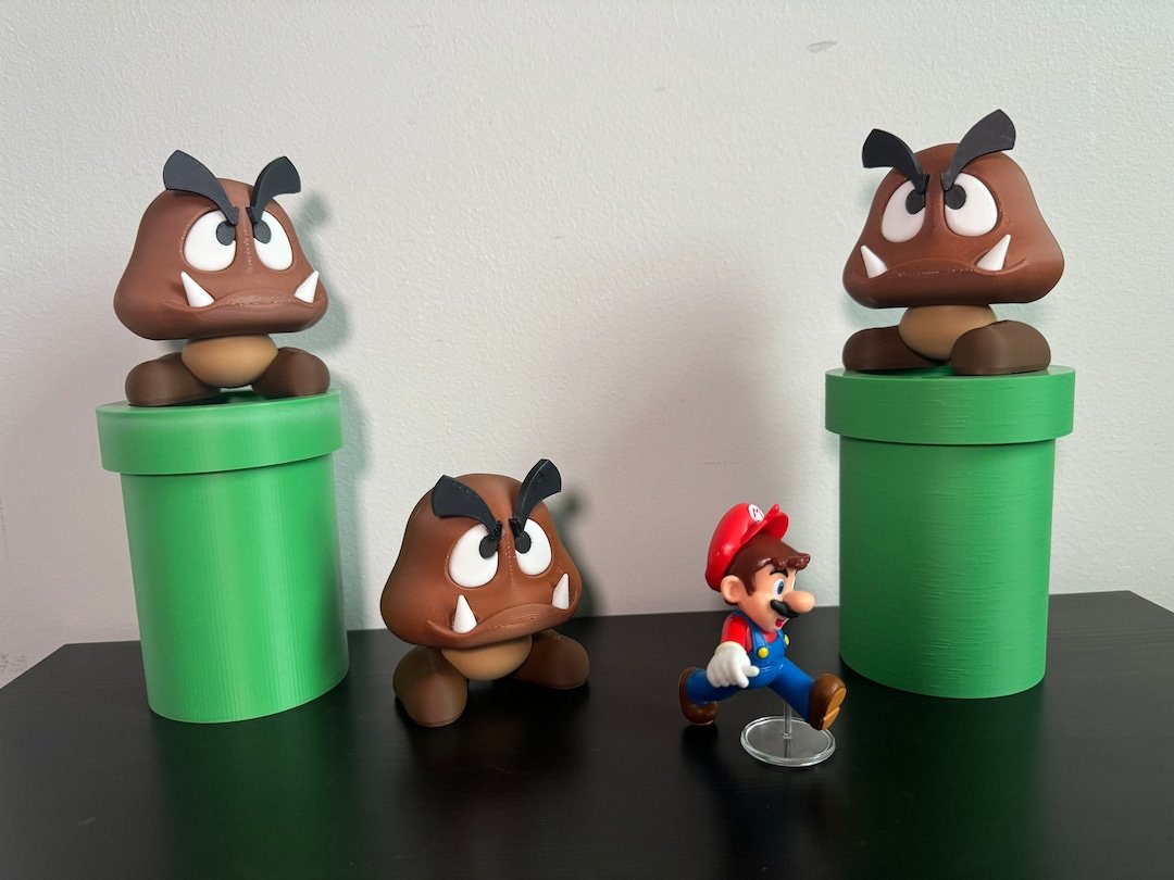 Cenário impresso em 3D com Mario, três Goombas e canos verdes