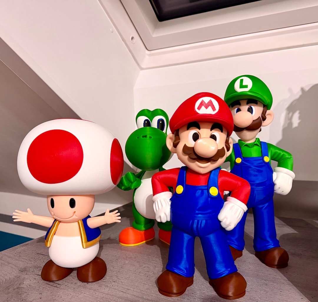Mario, Luigi, Toad e Yoshi impressos em 3D e coloridos sobre uma mesa